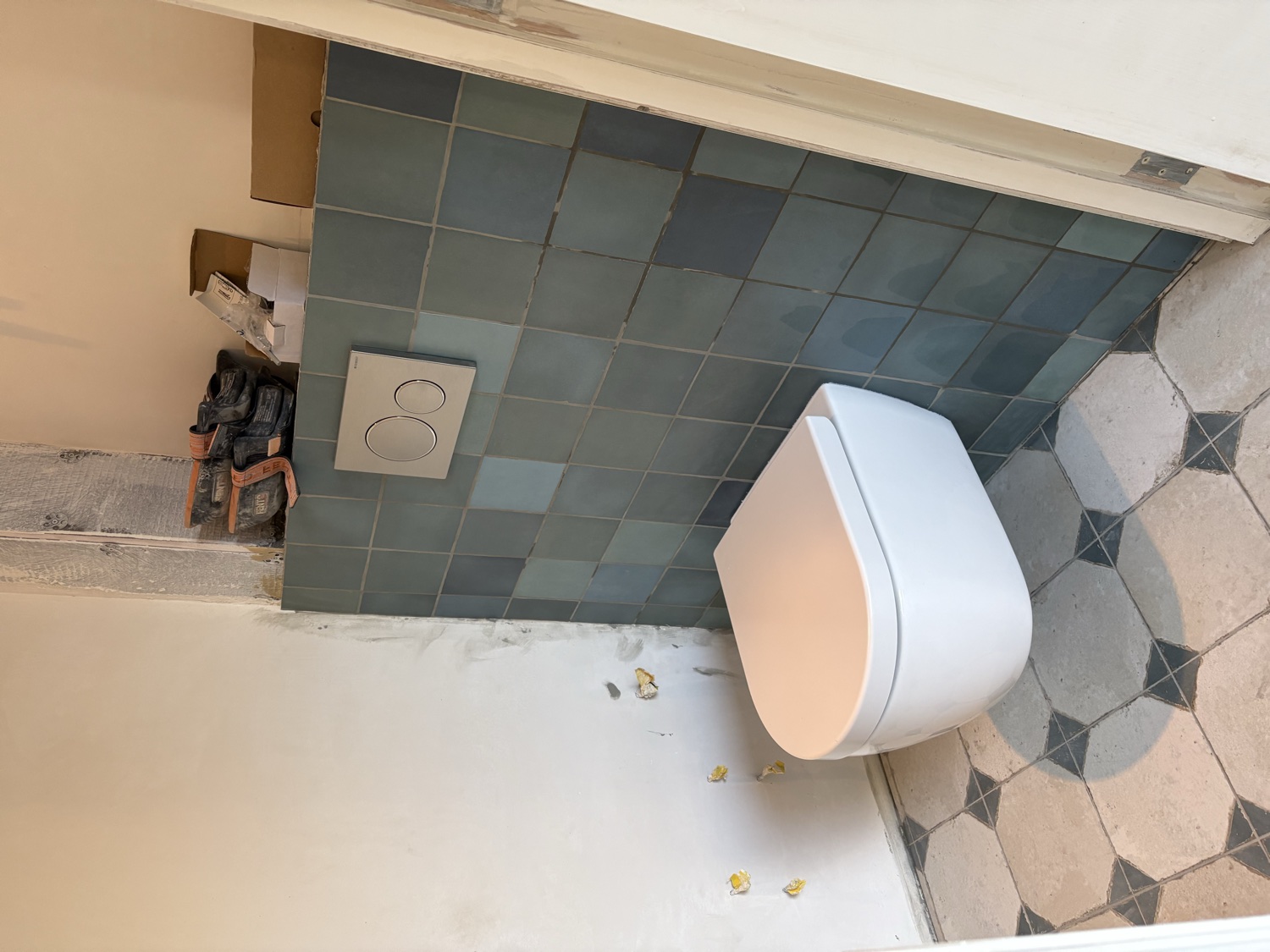 Zwevend toilet met zeegroene wandtegels